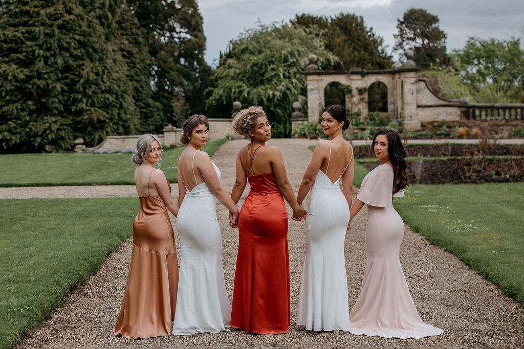 deep reddish-pink dress. red and white dresses from the back holding hands